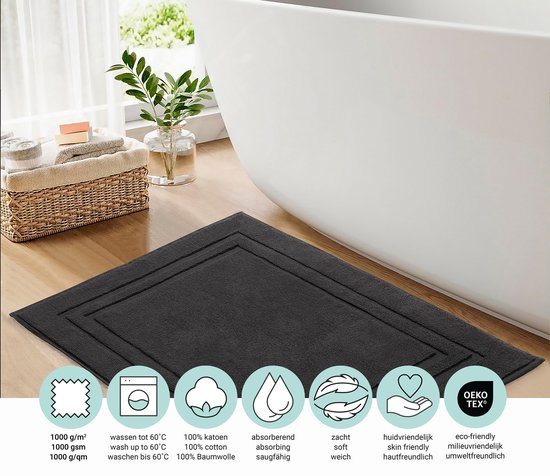 Zwarte badmat met kader naast een badkuip, met iconen voor 1000 g/m², wasbaar tot 60°C, 100% katoen, absorberend, zacht, huidvriendelijk en eco-tex.