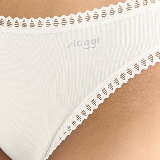 Close-up van crèmekleurige slip met gedetailleerd kanten randje en Sloggi-logo.