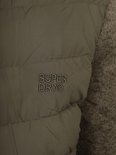 Close-up van het Superdry logo op de groene jas.