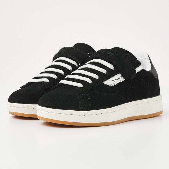 Paar zwarte suède sneakers met klittenbandsluiting en witte veters.