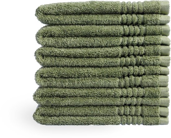 Pile de huit serviettes vert foncé, posées sur la tranche.