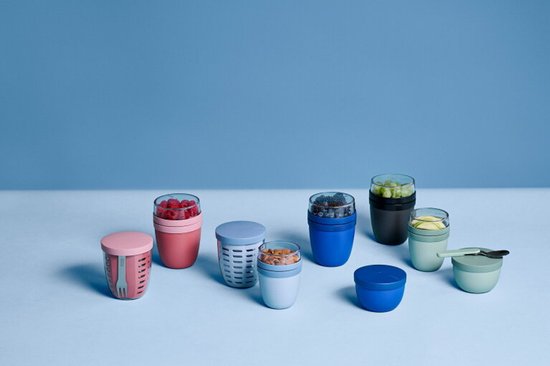 Collectie van Mepal lunchpots in diverse kleuren, gevuld met fruit, noten en ontbijtgranen.