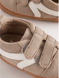 Bruine suède babysneakers met witte strepen en klittenbandsluiting.