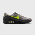 Gedetailleerd zij-aanzicht van een grijze Nike Air Max 90 sneaker met neon groene accenten.