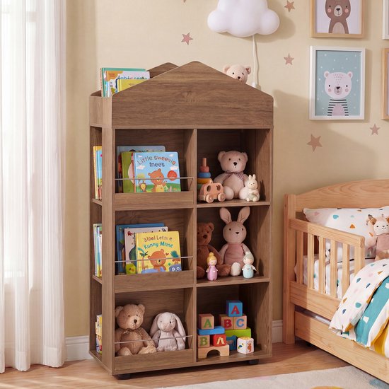 Bruine houten boekenkast in huisvorm met boeken en knuffels, naast een kinderbed.