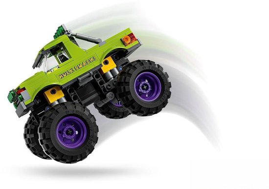 Groene LEGO monster truck met "HULK SMASH!" op de zijkant en paarse velgen, springend met rook-effect.