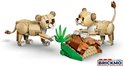 Twee gele lego leeuwenwelpen, met bruine oren, op een bruine stenen ondergrond met groene planten.