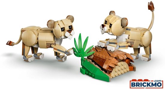 Twee gele lego leeuwenwelpen, met bruine oren, op een bruine stenen ondergrond met groene planten.