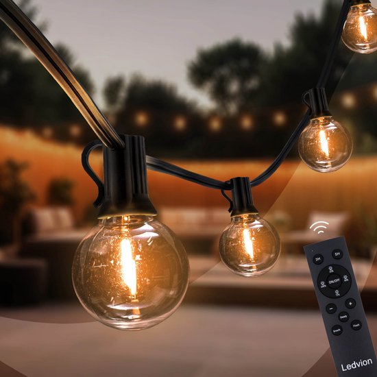 Warm wit LED-lichtsnoer met ronde G40-lampen en een zwarte afstandsbediening op een terras.