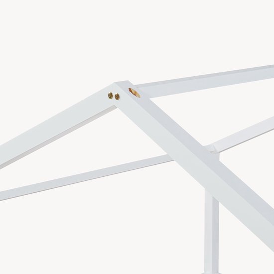 Gros plan de la structure de toit blanche en bois d'un lit maison.