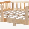 Détails d'un lit maison en bois naturel avec barreaux.
