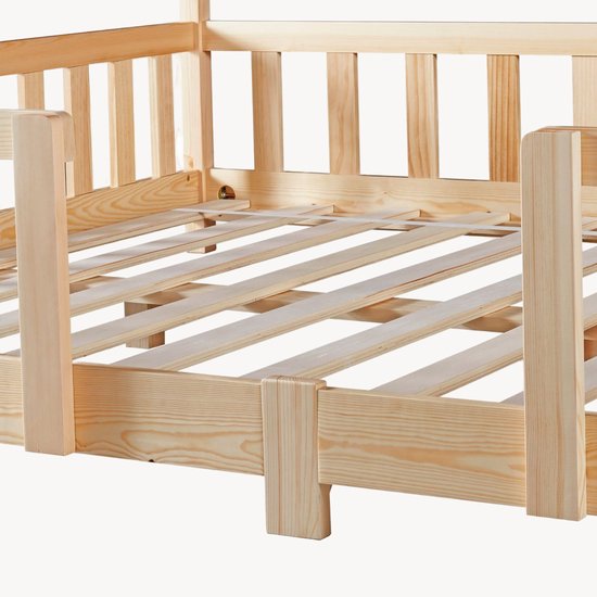 Détails d'un lit maison en bois naturel avec barreaux.