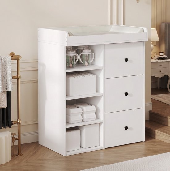 Witte commode met drie lades en open planken, gefotografeerd in een lichte, klassieke interieuromgeving.