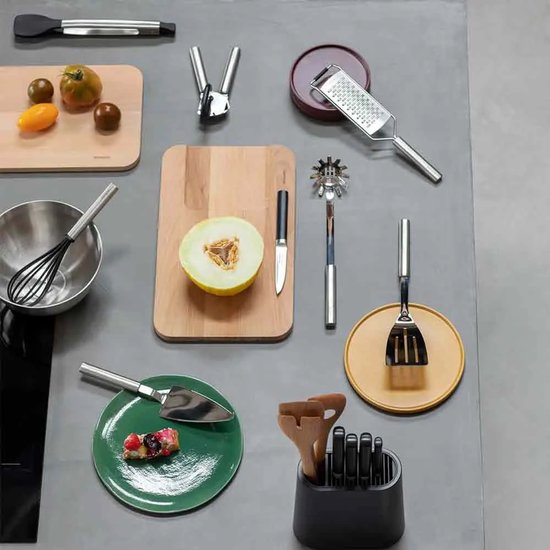 Un assortiment d'ustensiles de cuisine, y compris une pelle à tarte, un fouet, une râpe et une planche à découper avec un melon.