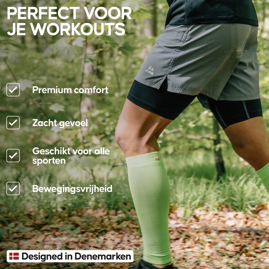 Man die traint in het bos met een grijze sportshort met ingebouwde zwarte onderbroek en lichtgroene compressiekousen.