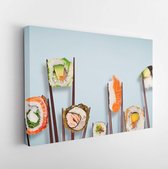 Traditionele japanse sushi-stukken geplaatst tussen eetstokjes, gescheiden op lichtblauwe pastelachtergrond. Zeer hoge resolutie afbeelding. - Moderne kunst canvas - Horizontaal -