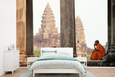 Behang - Fotobehang Monniken zitten te rusten in Angkor Wat - Breedte 450 cm x hoogte 300 cm