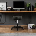 Zwarte draaikruk voor een bureau met computer en planten.