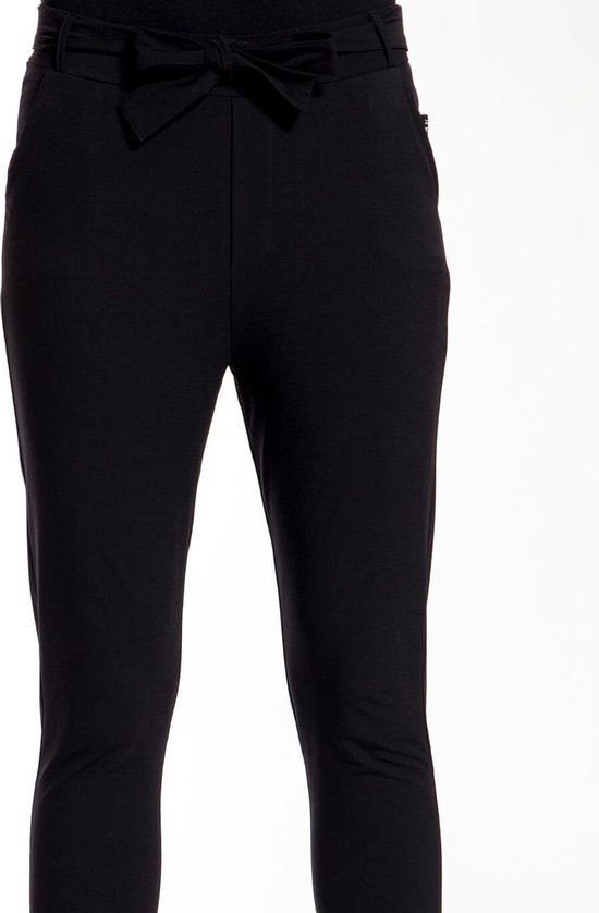 Detail van de tailleband met strik en steekzakken van een zwarte slim fit broek.