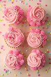 Zes roze cupcakes met verschillende decoraties en kleurrijke confetti.
