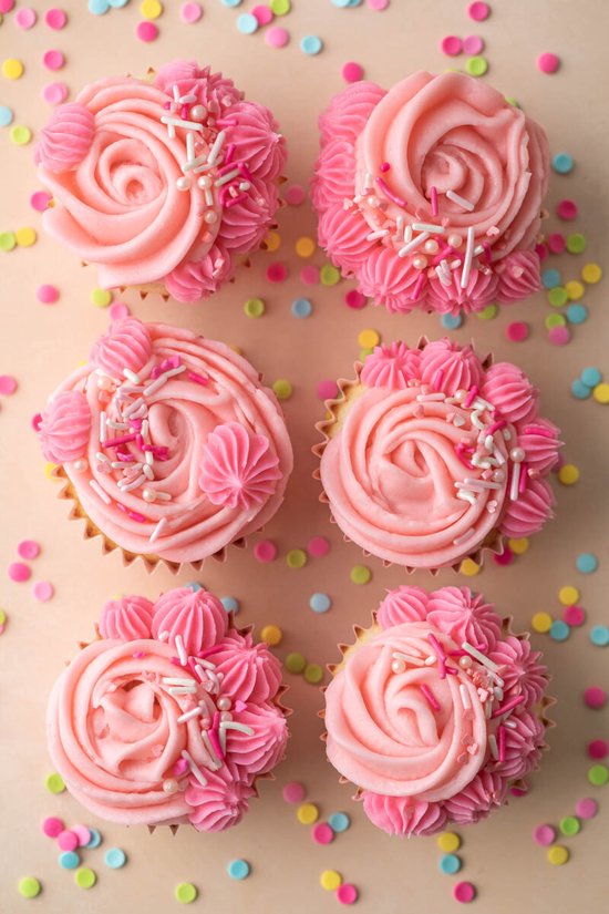 Zes roze cupcakes met verschillende decoraties en kleurrijke confetti.