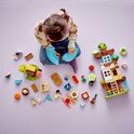 Kind speelt met LEGO DUPLO 3in1 Boomhut onderdelen: boomhut, figuren en accessoires.