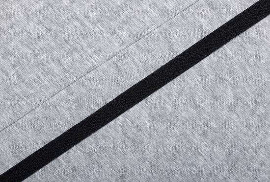 Close-up van grijze joggingbroekstof met een schuine zwarte band.