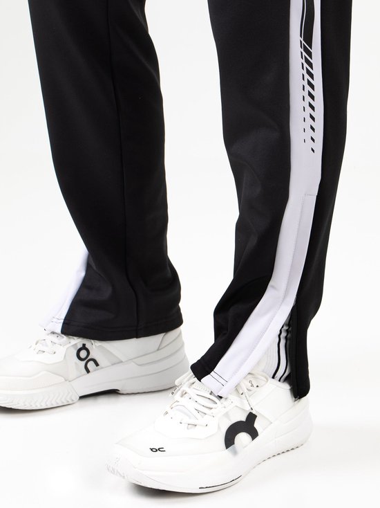 Achteraanzicht van de zwarte Sjeng Sports JANOS sportbroek met witte zijstrepen, gedragen door een man.