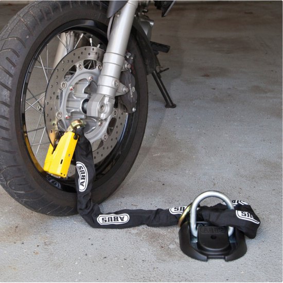 ABUS ketting met geel hangslot bevestigd aan motorwiel en zwart grondanker.