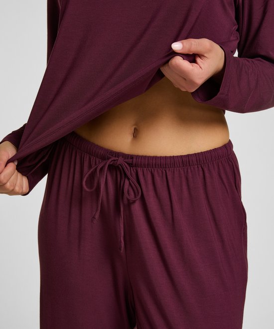 Gedetailleerd zicht op de paarse pyjamabroek met trekkoord, gedragen door een model.