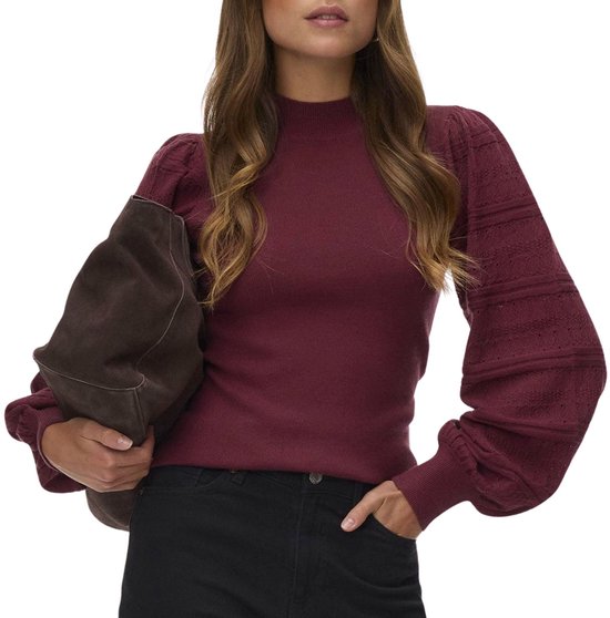 Model draagt bordeauxrode trui met hoge hals en ballonmouwen, met zwarte broek.