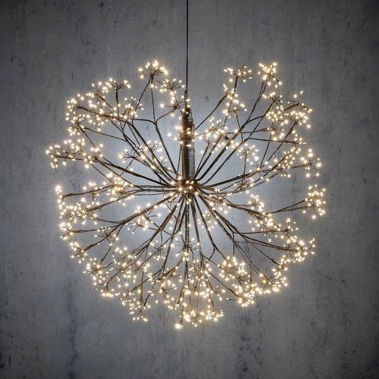 Une grande boule métallique noire avec des LED blanc chaud, comme une explosion de feux d'artifice, suspendue à un fil.