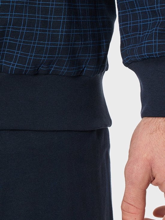 Detail van een donkerblauwe pyjamabroek met geruite top en elastische boorden.