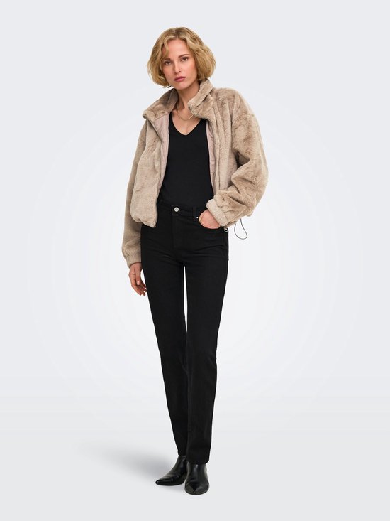 Model draagt open beige imitatiebont jack over zwarte top en broek, compleet met zwarte enkellaarsjes.