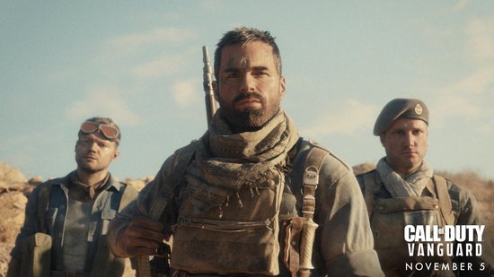 Drie soldaten op een rotsachtige achtergrond. De man op de voorgrond draagt een sjaal en geweer. Call of Duty: Vanguard.