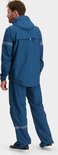Man in een blauw regenpak, staande vanaf de achterkant.