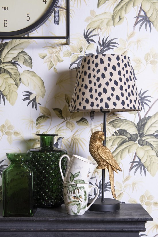 Twee groene vazen en gestapelde mokken met vogels en bladeren, bij een lamp met luipaardprint.