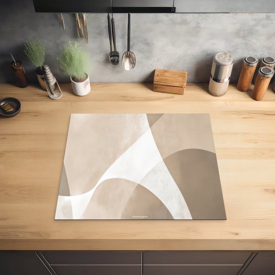 Inductiebeschermer met abstract beige patroon op een houten aanrecht, met keukengerei op de achtergrond.