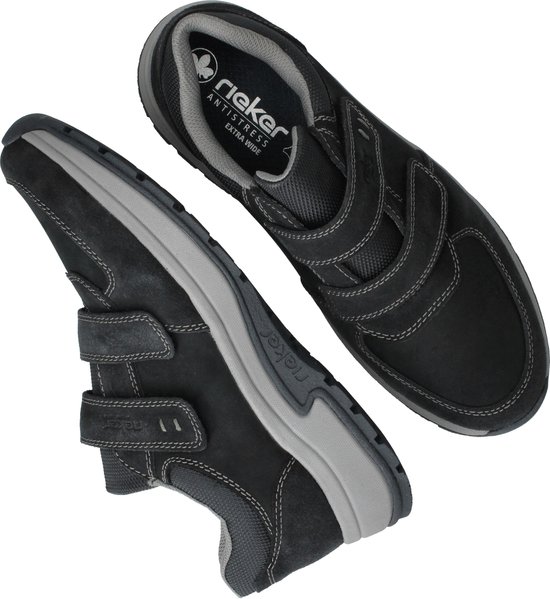 Zwarte suède sneakers met klittenbandsluitingen, diagonaal van bovenaf.
