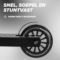Dichtbij detail van het wiel van een zwarte stuntstep met de tekst "100MM ABEC-9 BEARINGS".