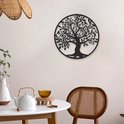 L'arbre de vie en métal noir est suspendu à un mur clair dans une salle à manger avec une table ronde et une chaise en rotin.