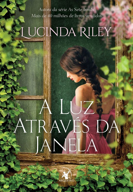 Boekomslag met Lucinda Riley's 'A Luz Através da Janela'. Vrouw met gevlochten bruin haar kijkt weg, draagt roze jurk, in raamkozijn met klimop.