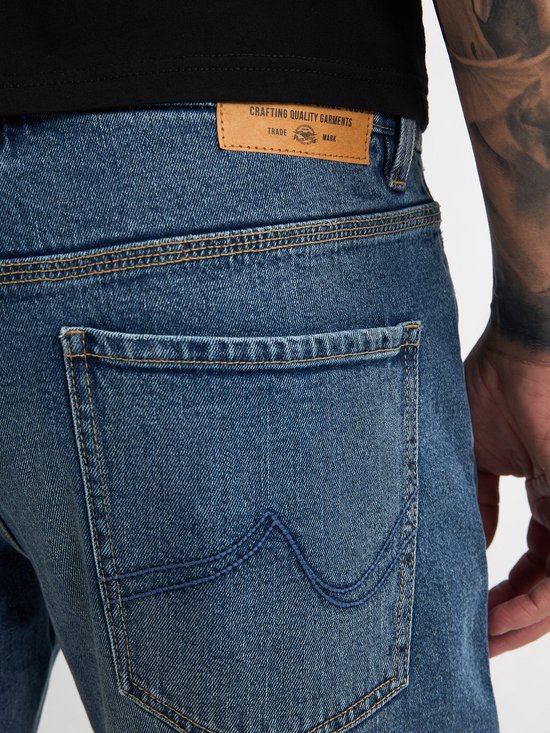 Detail van de achterkant van een blauwe jeans met leren label.
