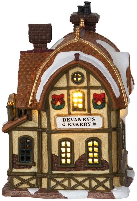 Verlicht Lemax 'Devaney's Bakery' gebouw met besneeuwd dak en schoorsteen.