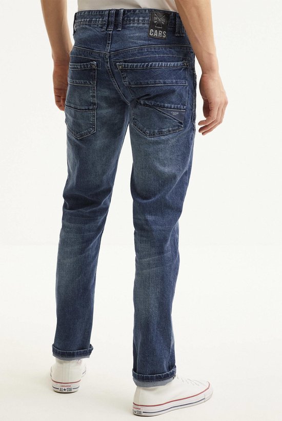 Man in blauwe jeans met stone wash used look, gedetailleerde naden. Achterkant met rolzomen.