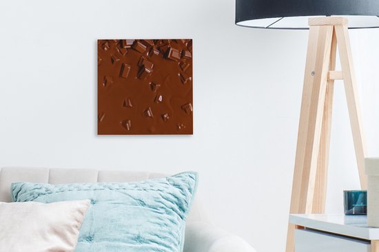Gros plan de chocolat fondu avec des morceaux, accroché au mur au-dessus d'un canapé.