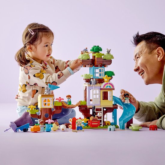 Vader en kind bouwen samen aan de LEGO DUPLO 3in1 Boomhut.