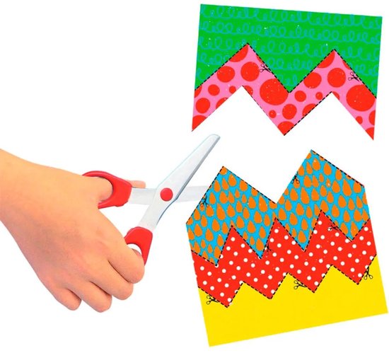 Hand knipt met schaar vellen met patronen: groen met krullen, roze met stippen en oranje met druppels.