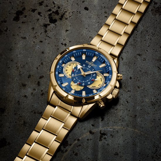 Gouden horloge met blauwe wijzerplaat en gouden band, liggend op een donkere, roestige ondergrond.