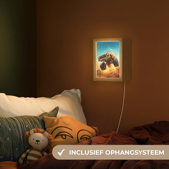 Een lamp met monstertruck naast een bed met kussens en dekens, inclusief ophangsysteem.